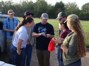A group of people viewing a bird banding demonstration